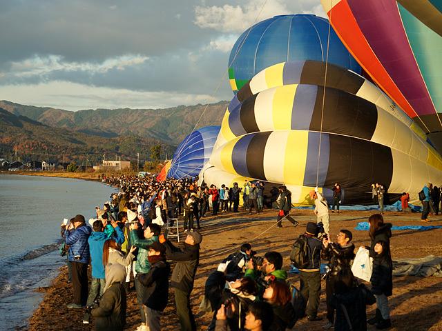 熱気球が朝日を浴びて琵琶湖へ